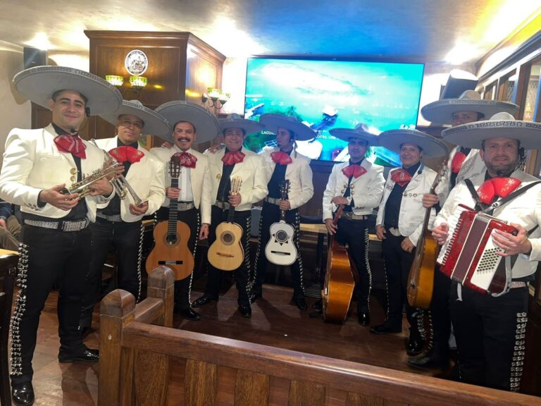 Actuación de Mariachi Toluca con traje blanco dentro de un restaurante